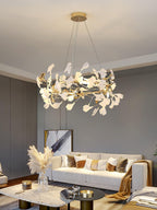 Clérachic gingko chandelier lit above a cream sofa, pampas grass in a glass vase below.
