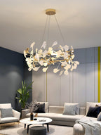 Clérachic gingko chandelier lit against blue panelling above a sectional and round table.