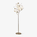 Clérachic gingko floor lamp on white, ceramic leaves clustered atop a slim gold stem with a round base.
