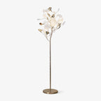 Clérachic gingko floor lamp on white, ceramic leaves clustered atop a slim gold stem with a round base.
