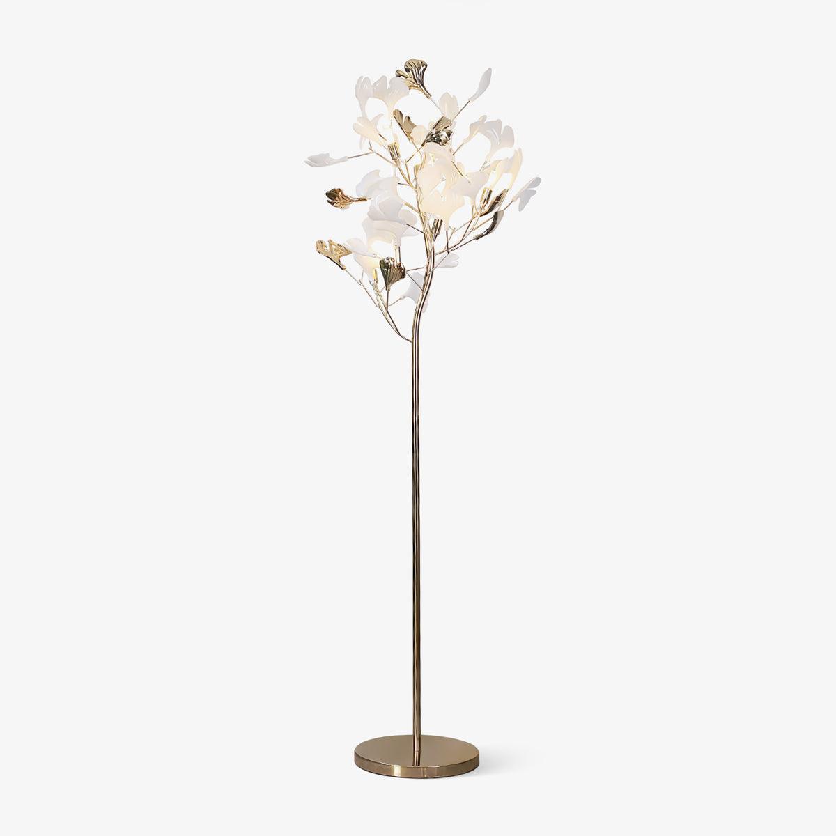 Clérachic gingko floor lamp on white, ceramic leaves clustered atop a slim gold stem with a round base.
