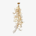 The Clérachic gingko cascade chandelier lit, leaves falling in a tapered column from a round gold canopy.