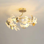 The Clérachic gingko ceiling light angled on a curved arm, gold and white leaves fanned out.