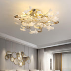 The Clérachic gingko ceiling light lit in a grey living room with a round mirror arrangement.