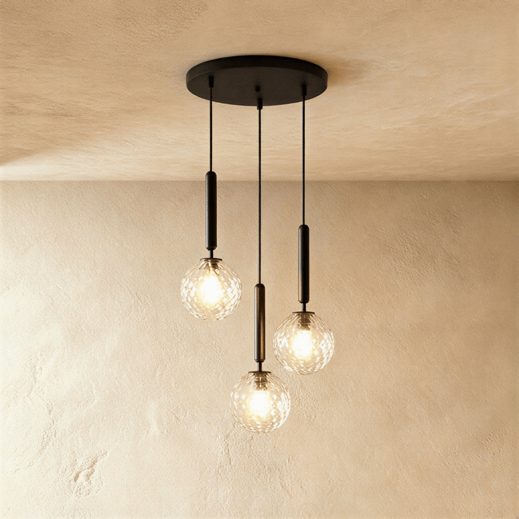 Clérachic three-head pendant on a round black canopy, with clear textured glass globes lit at staggered heights.