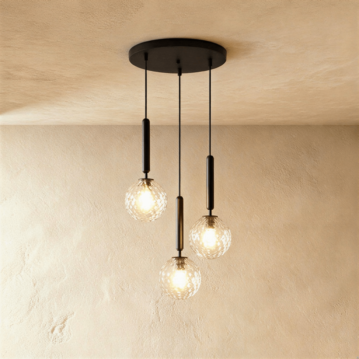Clérachic three-head pendant on a round black canopy, with clear textured glass globes lit at staggered heights.