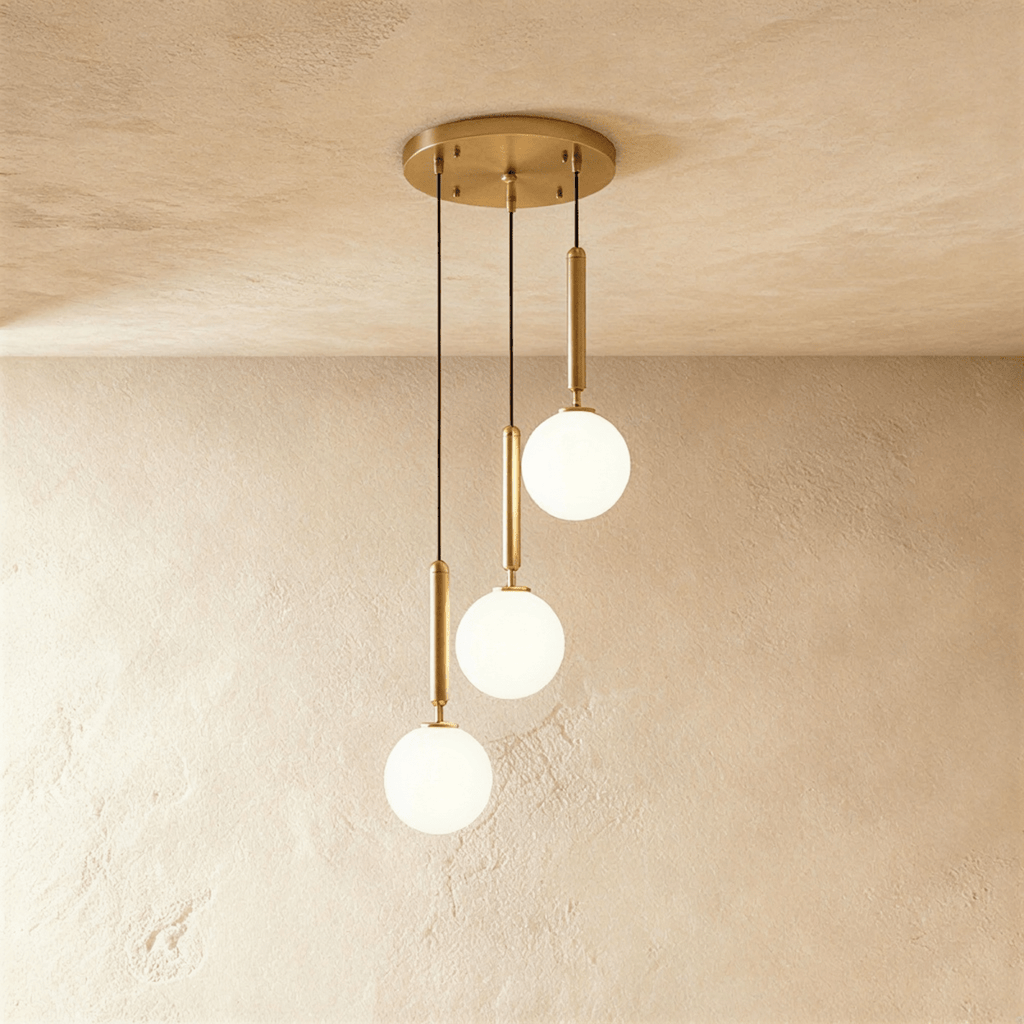 Clérachic three-head pendant on a round gold canopy, with milk white glass globes at three different drop lengths.