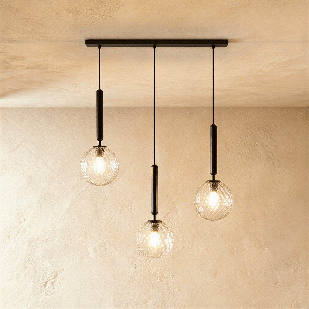 Clérachic three-head linear pendant on a black bar, with clear textured glass globes and lit bulbs at varied heights.