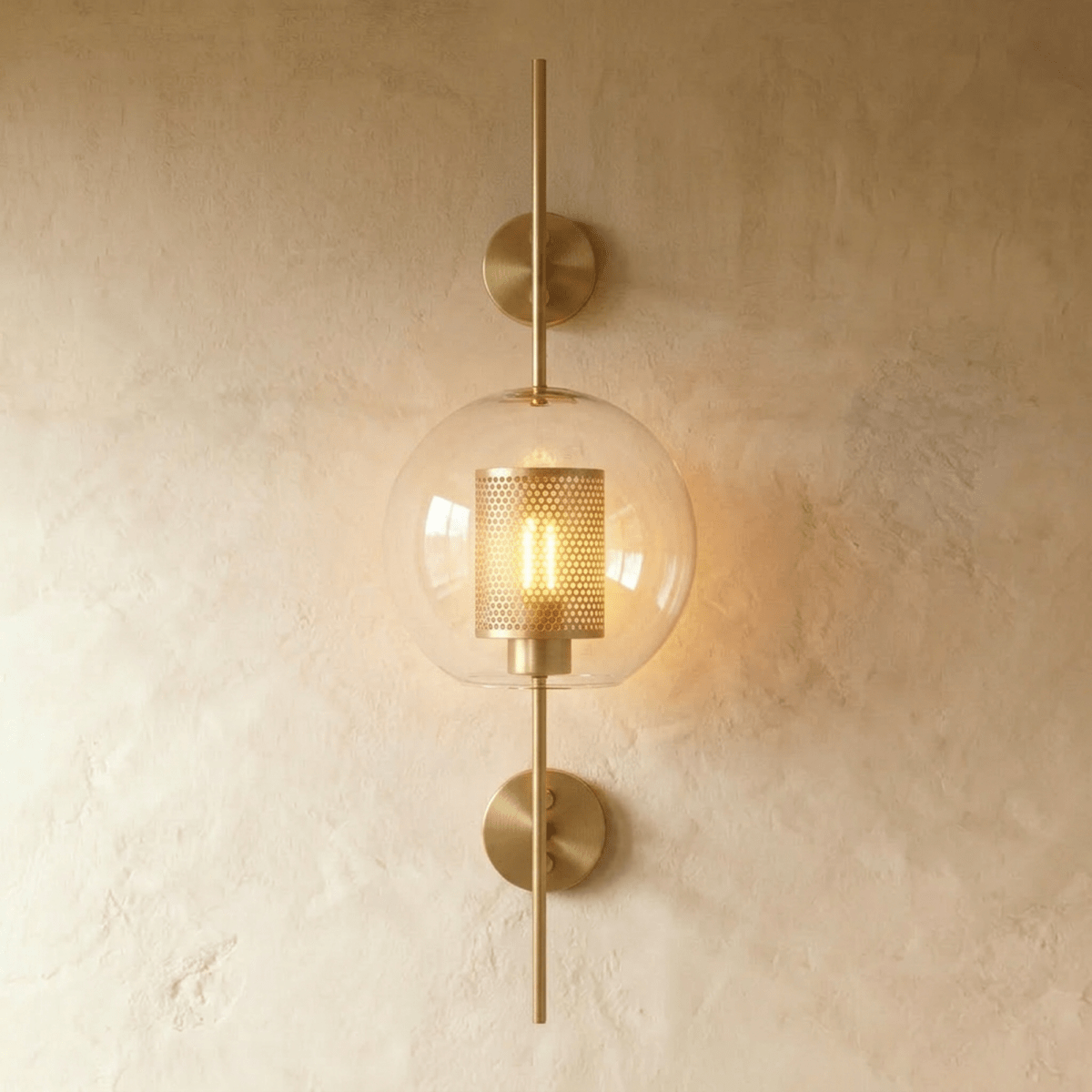 Clérachic wall lamp in the globe shade, clear glass rounded around the lit perforated cylinder at its centre.