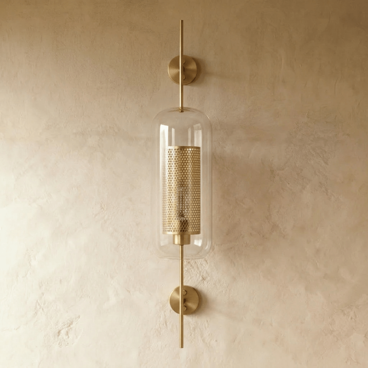 Clérachic wall lamp's capsule shade shown head-on, with the two round brass wall plates visible above and below the glass.
