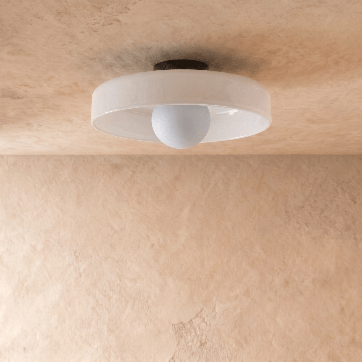 Clérachic shallow white glass disc ceiling light, switched off, showing a pale opal globe bulb and slim black canopy.