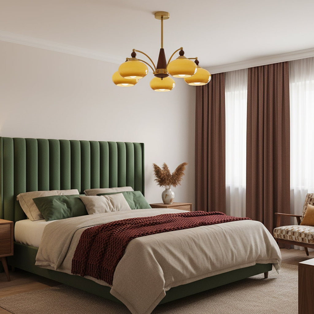This Clérachic chandelier with caramel glass shades hangs above a bed with a green velvet headboard and rust-red throw.