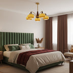 This Clérachic chandelier with caramel glass shades hangs above a bed with a green velvet headboard and rust-red throw.