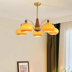 This Clérachic chandelier with caramel glass shades hangs in a cream room with green curtains and a framed print in the corner.