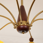Close view of the walnut-toned wooden column and gold arms at the centre of this Clérachic chandelier.