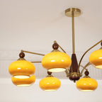 Caramel glass shades with gold rims and wooden finials, seen from below on this Clérachic chandelier.