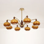 Unlit Clérachic chandelier with deep brown caramel glass shades on gold arms, hung against a white moulded ceiling.