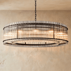 Clérachic widest drum chandelier of fluted glass rods with matte black studs and a tiered inner ring, lit warm on a chain.