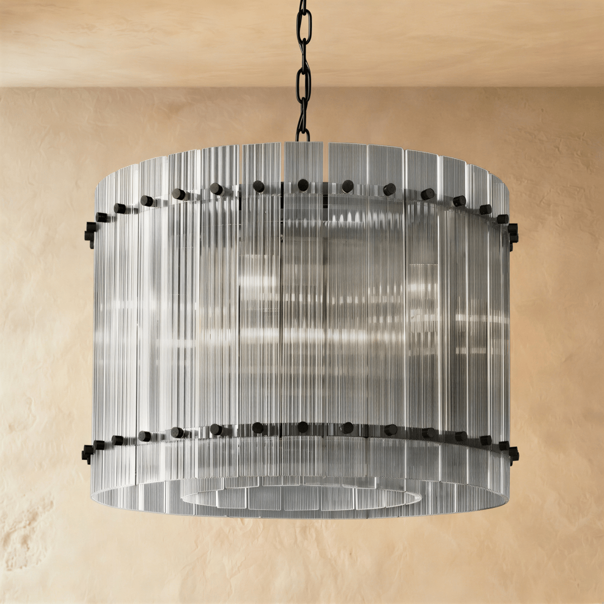 Clérachic compact drum chandelier of clear fluted glass rods with matte black studs, switched off and see-through on a chain.