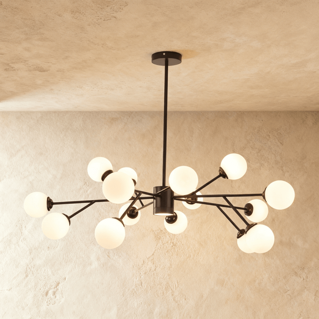 Clérachic branching chandelier in matte black, opal glass globes clustered densely and glowing warm.