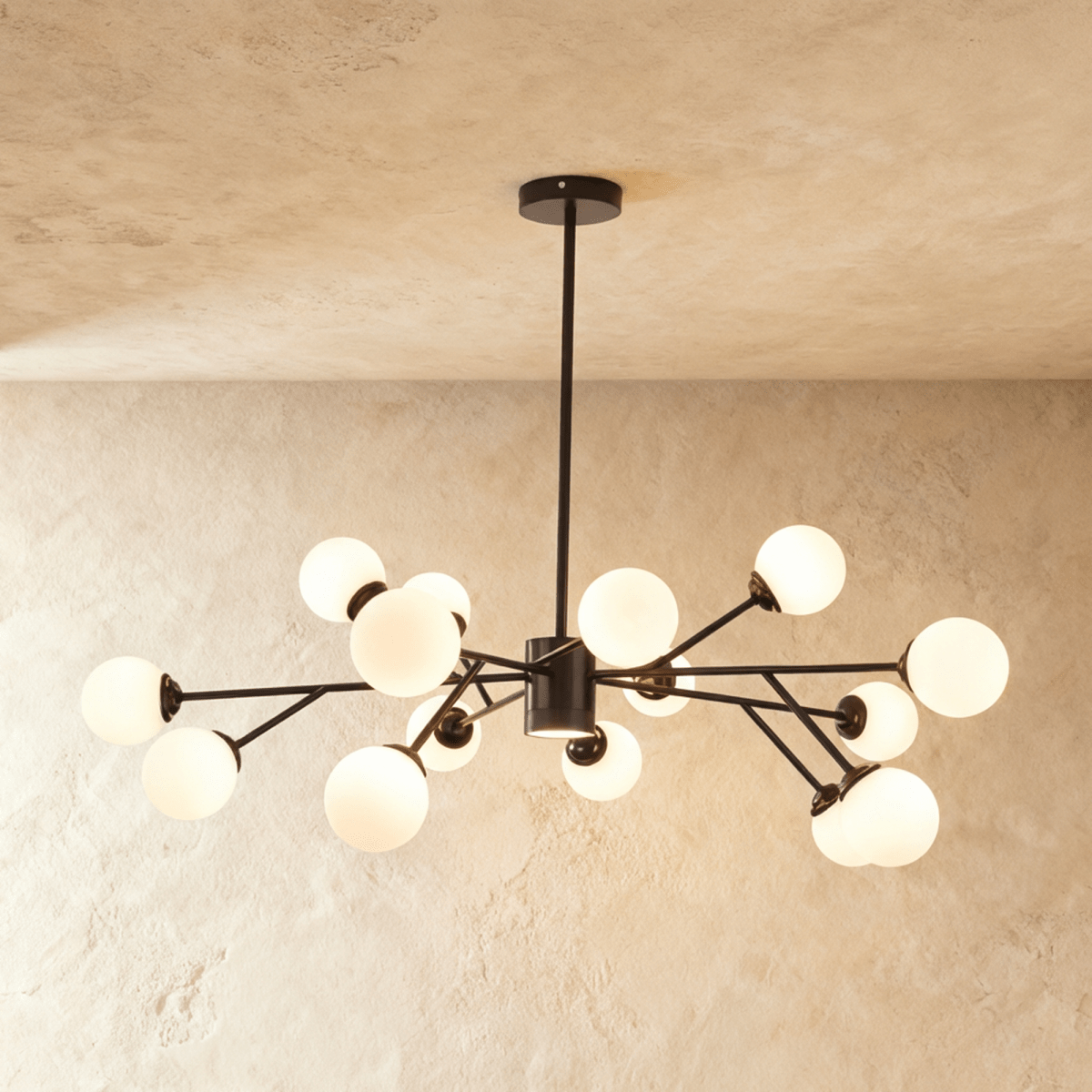 Clérachic branching chandelier in matte black, opal glass globes clustered densely and glowing warm.