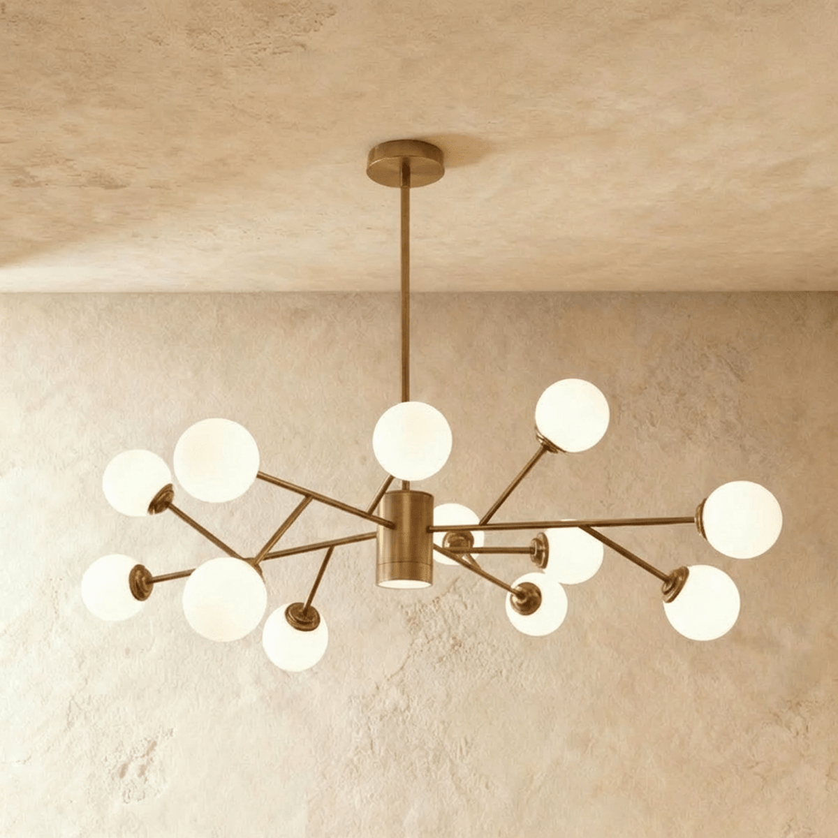 Clérachic branching chandelier in brushed gold, opal glass globes clustered densely across angled brass arms.