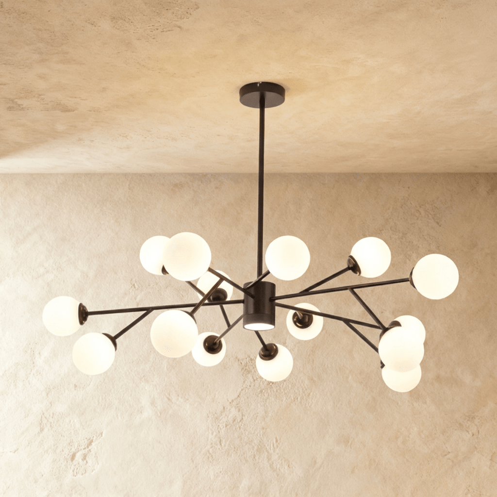 Clérachic branching chandelier in matte black, a wide dense spread of opal glass globes lit warm.