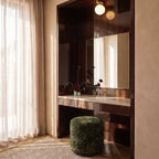 Clérachic flush-mount light in gold above a lacquered vanity, its opal globe reflected in the mirror.