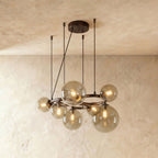 Clérachic globe cluster chandelier in Smoky Gray Glass, tinted glass spheres on a dark ring against plaster.