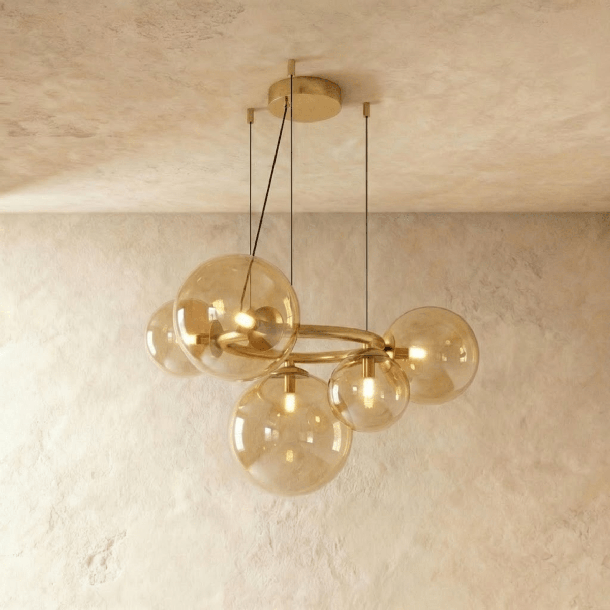 Clérachic globe cluster chandelier in Amber Glass, warm-tinted spheres clustered on a brass ring frame.
