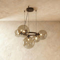 Clérachic globe cluster chandelier in Smoky Gray Glass, its tinted spheres grouped on a dark metal ring.