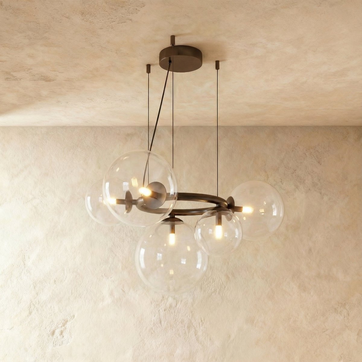 Clérachic globe cluster chandelier in Clear Glass, viewed from another angle with bulbs glowing inside each sphere.
