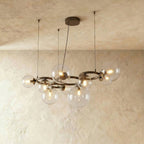 Clérachic globe cluster chandelier in Clear Glass, its dark ring frame holding clear spheres with visible bulbs.