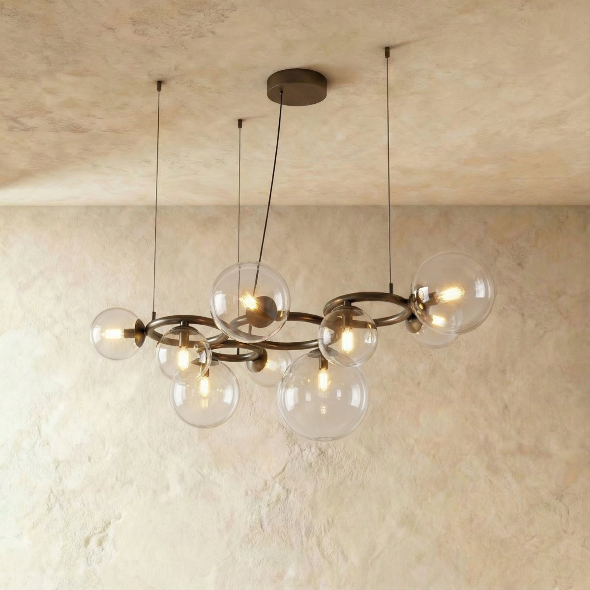 Clérachic globe cluster chandelier in Clear Glass, its dark ring frame holding clear spheres with visible bulbs.