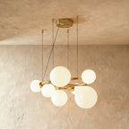 Clérachic globe cluster chandelier in Milk White Glass, opaque white spheres grouped on a brass ring frame.