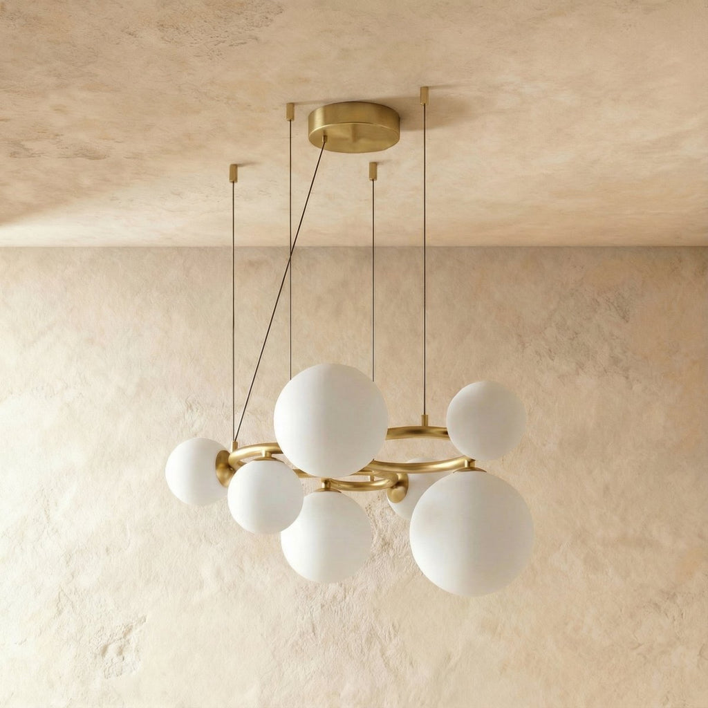 Clérachic globe cluster chandelier in Milk White Glass, its opaque spheres clustered on a brushed brass ring.