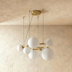 Clérachic globe cluster chandelier in Milk White Glass, its opaque spheres clustered on a brushed brass ring.