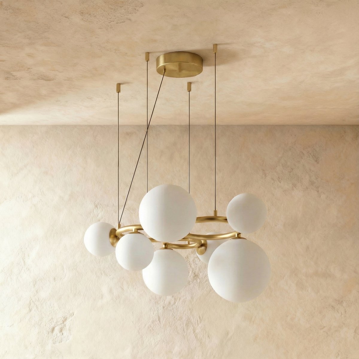Clérachic globe cluster chandelier in Milk White Glass, its opaque spheres clustered on a brushed brass ring.