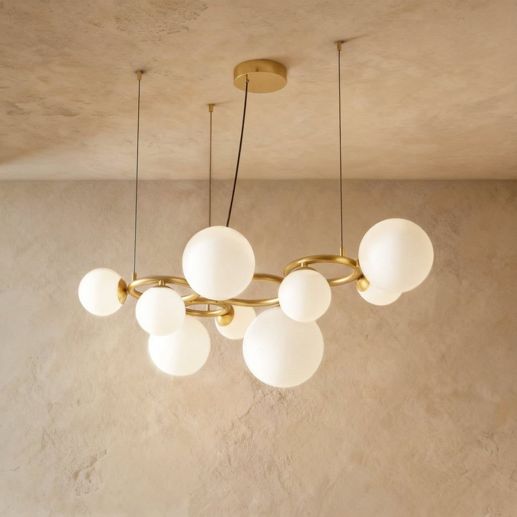 Clérachic globe cluster chandelier in Milk White Glass, a larger cluster of opaque spheres on a brass ring frame.