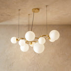 Clérachic globe cluster chandelier in Milk White Glass, a larger cluster of opaque spheres on a brass ring frame.