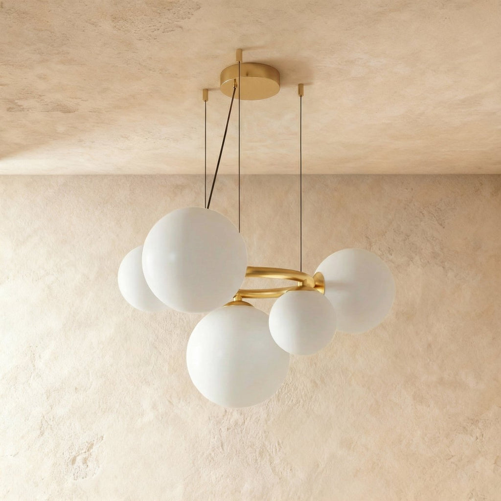 Clérachic globe cluster chandelier in Milk White Glass, opaque spheres clustered tightly on its brass ring.