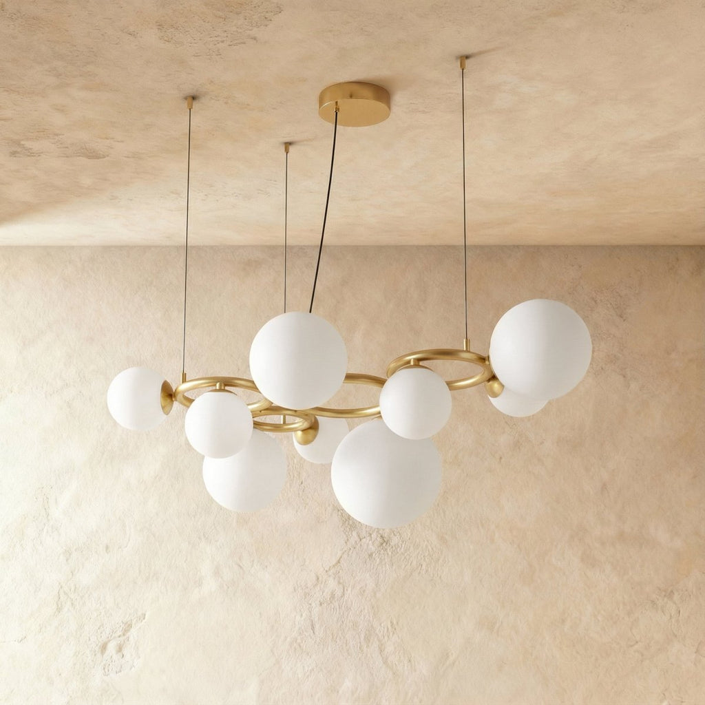 Clérachic globe cluster chandelier in Milk White Glass, a wider cluster of opaque spheres on a brass ring frame.