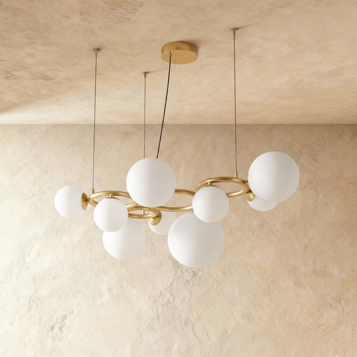 Clérachic globe cluster chandelier in Milk White Glass, a wider cluster of opaque spheres on a brass ring frame.