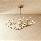Clérachic branch chandelier densely set with frosted glass globes lit warm, bronze branches spread wide.