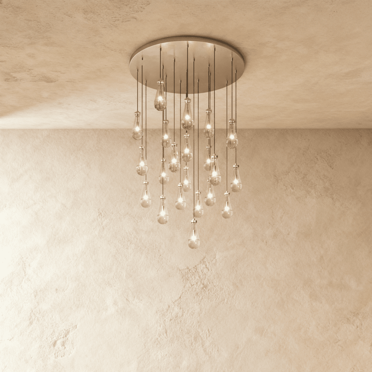 Clérachic chandelier with 21 clear glass teardrops on thin cords from a round satin nickel canopy, glowing warm, against limewashed plaster