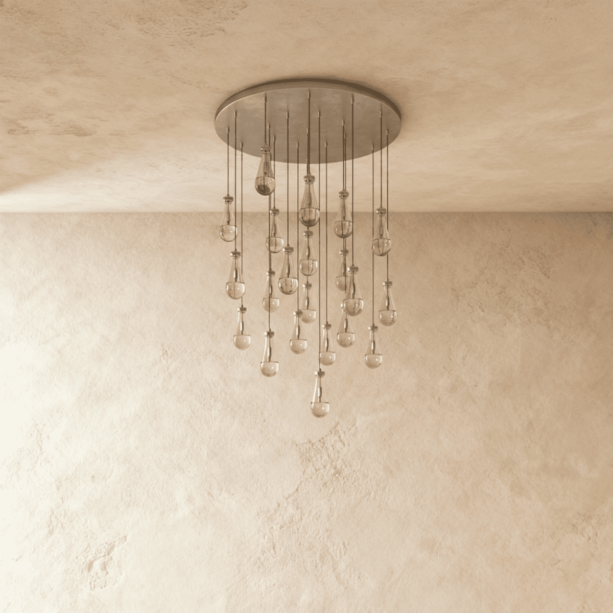 Clérachic chandelier with 21 clear glass teardrops on thin cords from a round satin nickel canopy, switched off, against limewashed plaster