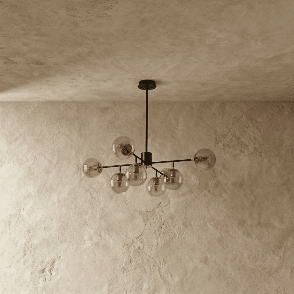 Clérachic black chandelier with 7 cognac-tinted glass globes on straight arms, unlit, against a limewash wall.