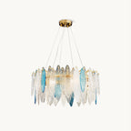Round Clérachic glass chandelier on a plain white backdrop, with clear and blue leaf-shaped panels on a gold frame.