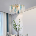Clérachic chandelier with clear and blue glass leaves in a bright room, a leafy branch in a vase below.
