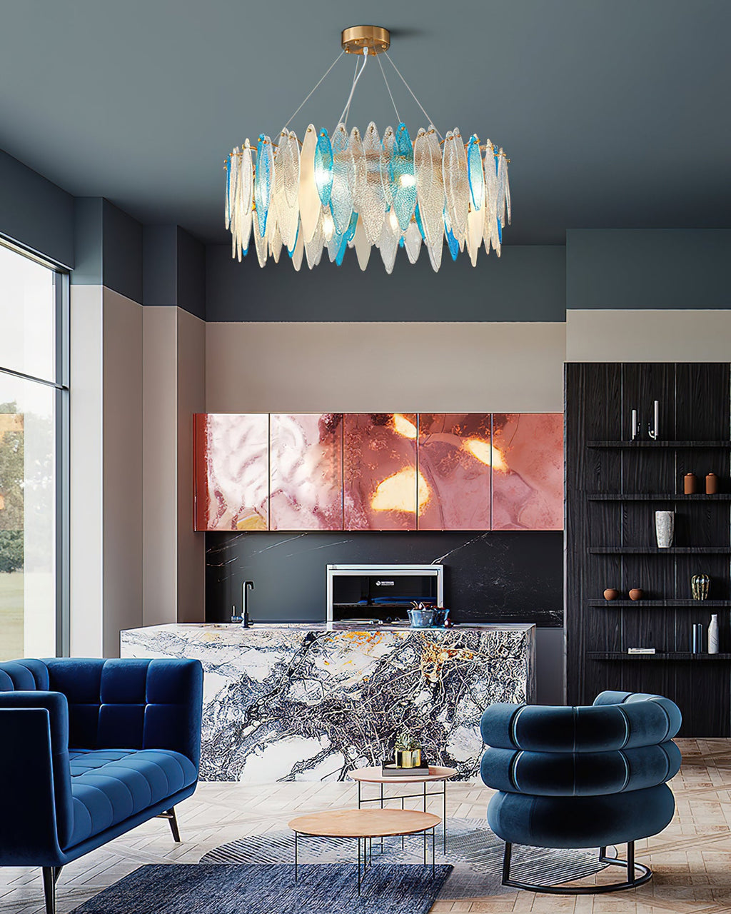 Tall view of a Clérachic blue and clear glass chandelier over a lounge with navy velvet chairs.